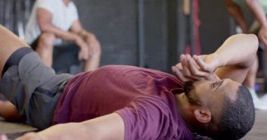 Beden eğitiminde ağır çekimde yatıp dinlenen bitkin, melez bir adam. Sağlıklı yaşam tarzı, çapraz eğitim, spor ve spor.