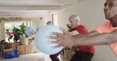 Farklı yaşlılara odaklanarak ağır çekimde, değişmeden pilates sınıfında top tutuyorlar. Egzersiz, emeklilik ve sağlıklı bir yaşam tarzı..