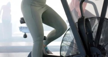 Spor salonunda eliptik bisikletler üzerinde yavaş çekimde çalışan değişmez farklı kadınlar. Sağlıklı yaşam tarzı, eğitim, motivasyon, güç, fitness ve egzersiz.