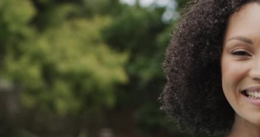 Afro-Amerikan kadın portresi gülümseyen ve bahçede kameraya bakan, fotokopi çeken, ağır çekim. Yaşam tarzı ve ev hayatı.