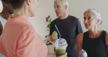 Mutlu son sınıflar bayan pilates koçuyla konuşuyor ve içki içiyor, değişmeden, ağır çekimde. Egzersiz, emeklilik ve sağlıklı bir yaşam tarzı..