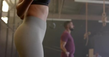 Çeşitli kadın ve erkek antrenmanlarının orta kısmı ağır çekimde atlama halatı. Sağlıklı yaşam tarzı, çapraz eğitim, fitness, güç ve egzersiz.
