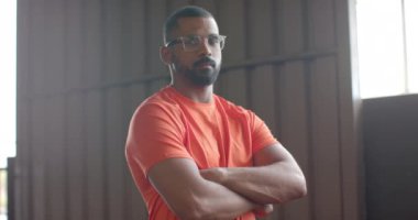 Gözlüklü, spor salonunda kameraya gülümseyen Afrikalı Amerikalı adamın portresi. Fitness, sağlıklı yaşam tarzı ve özgüven.