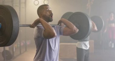Çeşitli erkek grupları ağırlık kaldırıyor, spor salonunda ağırlık çalışması yapıyor, ağır çekimde. Sağlıklı yaşam tarzı, ağırlık çalışması, spor, motivasyon, güç ve egzersiz.