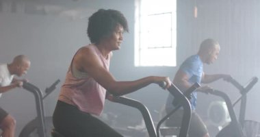 Spor salonunda ağır çekimde egzersiz yapan farklı sporcuların portresi. Sağlık, spor ve aktif yaşam tarzı.