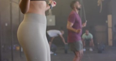 Çeşitli kadın ve erkek antrenmanlarının orta kısmı ağır çekimde atlama halatı. Sağlıklı yaşam tarzı, çapraz eğitim, fitness, güç ve egzersiz.