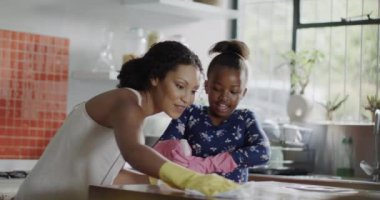 Mutlu Afro-Amerikan anne ve kızı birlikte mutfağa çekiliyor, ağır çekimde. Yaşam tarzı, aile ve aile hayatı.