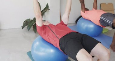 Farklı üst sınıflar, kadın pilates koçuyla egzersiz toplarını yavaş çekimde kullanıyor. Egzersiz, emeklilik ve sağlıklı bir yaşam tarzı..