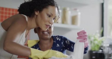 Mutlu Afro-Amerikan anne ve kızı birlikte mutfağa çekiliyor, ağır çekimde. Yaşam tarzı, aile ve aile hayatı.