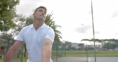 Açık havada tenis oynayan iki farklı erkek arkadaşın görüntüsü, yavaş çekim. Spor, rekabet, arkadaşlık, yaşam tarzı, eğlence ve etkinlik.