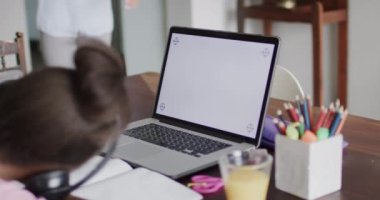 Mutlu Afro-Amerikan anne ve kızı ekranda fotokopi alanı olan dizüstü bilgisayar kullanıyor, yavaş çekim. Yaşam tarzı, iletişim, aile ve aile hayatı.