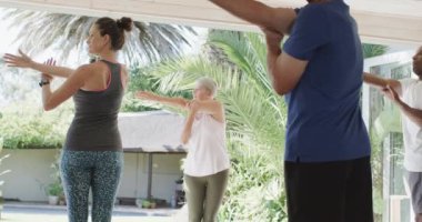 Farklı yaşlarda kadın koçla pilates kursuna odaklanmış, değişmemiş, ağır çekimde. Egzersiz, emeklilik ve sağlıklı bir yaşam tarzı..