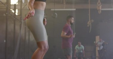 Spor salonunda yavaş çekimde atlama eğitimi alan çeşitli erkek ve kadınlar. Sağlıklı yaşam tarzı, çapraz eğitim, fitness, güç ve egzersiz.