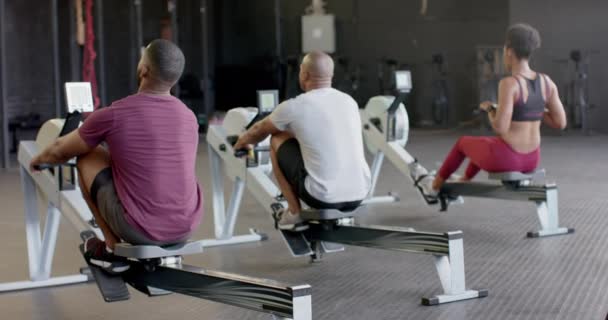 不同团体健身班的后视镜在体育馆里对划船机进行了艰苦的训练 动作缓慢 健康的生活方式 交叉训练 力量和锻炼 — 图库视频影像
