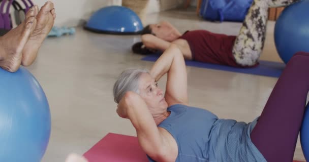 Konzentrierte Senioren Mit Übungsbällen Pilates Kurs Unverändert Zeitlupe Bewegung Ruhestand — Stockvideo
