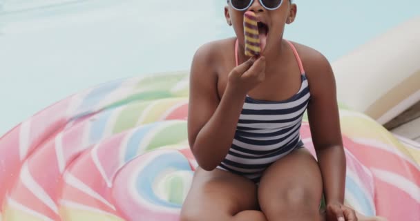 Портрет Счастливой Африканской Девушки Улыбающейся Поедающей Мороженое Бассейна Замедленная Съемка — стоковое видео