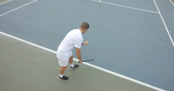 スローモーションで屋外テニスコートでボールを提供する準備白人男性テニス選手 スポーツ ライフスタイル レジャー アクティビティ — ストック動画