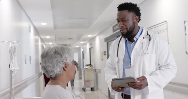 Různorodý Seriózní Mužský Lékař Tabletou Hovořící Starším Pacientem Lůžku Zpomaleném — Stock video