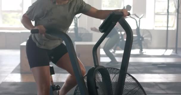 决心不变的高加索女人训练椭圆自行车在健身房 慢动作 健康的生活方式 健康和锻炼 — 图库视频影像