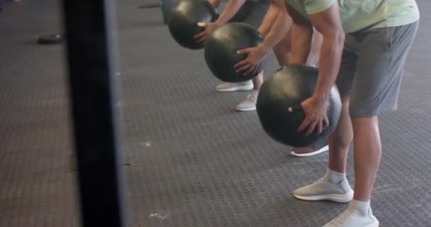 不同的男子团体健身班训练在健身房举重和扔药丸 动作缓慢 健康的生活方式 交叉训练 力量和锻炼 — 图库视频影像