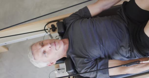 Focused Senior Caucasian Man Using Reformer Female Pilates Coach Unaltered — Stock Video