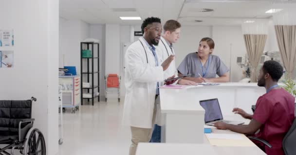 ゆっくりとした動きで受付で話す多様な男性と女性の医師や看護師を 変更されずに忙しい 病院の廊下 — ストック動画