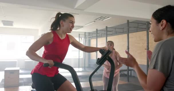 在团体健身课上 不变的多样化女性激励女性骑椭圆自行车 动作缓慢 健康的生活方式 健康和锻炼 — 图库视频影像