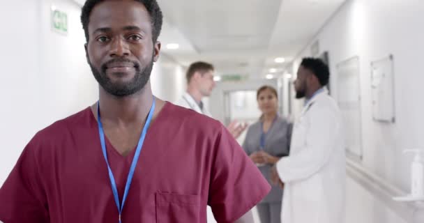 Portret Szczęśliwego Afrykańskiego Pielęgniarza Płci Męskiej Różnymi Lekarzami Chodzącymi Zwolnionym — Wideo stockowe