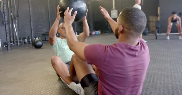 两个不同的人一起运动 坐起来 在体育馆里慢动作地传递药物球 健康的生活方式 交叉培训 团队精神 力量和锻炼 — 图库视频影像