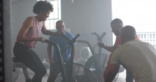 Grup Fitness Sınıfındaki Erkekler Tarafından Desteklenen Eliptik Bisikletteki Kararlı Kadın — Stok video