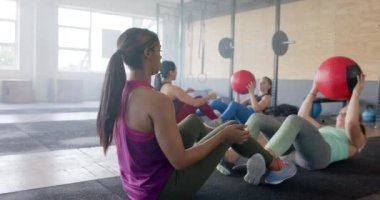 Değiştirilmemiş kadın grupları spor salonunda, yavaş çekimde, fotokopi alanında ilaç toplarıyla çiftler halinde antrenman yapıyor. Sağlıklı yaşam tarzı, çapraz eğitim, motivasyon, güç, fitness ve egzersiz.