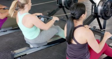 Değişime uğramamış kadınlar spor salonunda kürek çekiyorlar, ağır çekimde. Sağlıklı yaşam tarzı, çapraz eğitim, motivasyon, güç, fitness ve egzersiz.