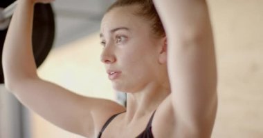 Ağırdan alarak spor salonunda ağırlık kaldırma antrenmanına odaklanmış beyaz kadın. Sağlıklı yaşam tarzı, ağırlık çalışması, motivasyon, güç, fitness ve egzersiz.