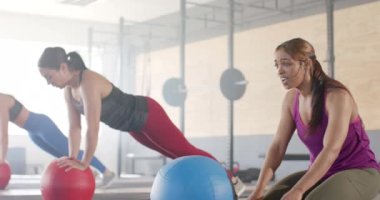Fitness sınıfında ilaç topuyla egzersiz yaptıktan sonra değişmemiş melez bir kadın, ağır çekimde. Sağlıklı yaşam tarzı, çapraz eğitim, motivasyon, güç, fitness ve egzersiz.
