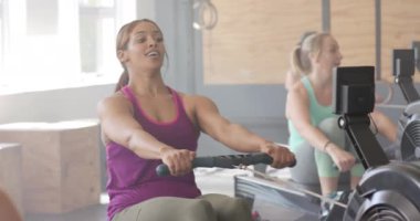 Yavaş çekimde spor salonunda kürek çeken değişmemiş farklı kadınlara odaklanmış. Sağlıklı yaşam tarzı, çapraz eğitim, motivasyon, güç, fitness ve egzersiz.
