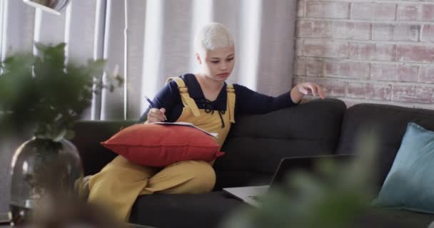 遅い動きでソファの上のラップトップで家で働く忙しい出産の女性 家庭生活 ライフスタイル テクノロジー — ストック動画