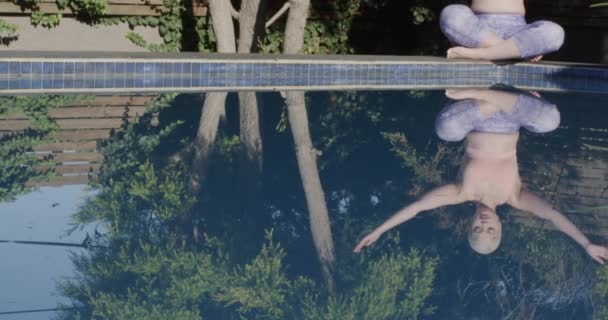 ヨガを練習し スローモーションで庭のプールで瞑想に焦点を当てた出産の女性 国内生活 — ストック動画