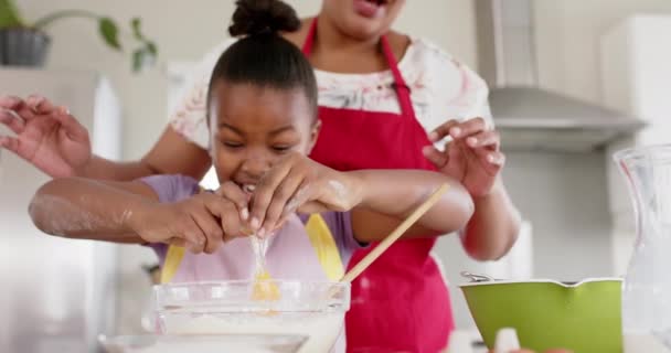 幸せな変更されていないアフリカ系アメリカ人の母親と娘の台所で焼く スローモーションで ライフスタイル 団結と国内生活 — ストック動画