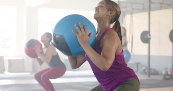 Zdeterminowana Birasowa Kobieta Podnosząca Piłkę Medyczną Zajęciach Fitness Sali Gimnastycznej — Wideo stockowe