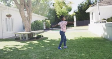 Afrikalı Amerikalı çocuk bahçede yavaş çekimde oynuyor. Yaşam tarzı, çocukluk, doğa ve ev hayatı.