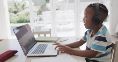 Afrikalı Amerikalı çocuk bilgisayarını online ders olarak kullanıyor, ağır çekimde. Yaşam tarzı, çocukluk, iletişim ve ev hayatı.