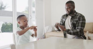 Afro-Amerikan baba ve oğlu işaret dilini yavaş çekimde kullanıyor. Yaşam tarzı, aile, sakatlık, sağırlık ve ev hayatı.