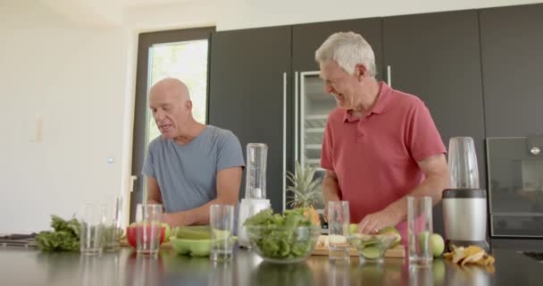 Glückliche Ältere Kaukasische Männerfreunde Bereiten Der Küche Gesundheitsgetränke Unverändert Zeitlupe — Stockvideo