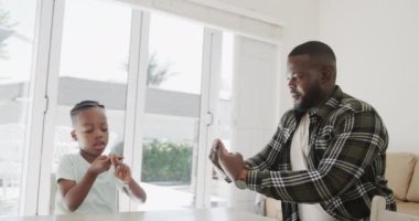 Afro-Amerikan baba ve oğlu işaret dilini yavaş çekimde kullanıyor. Yaşam tarzı, aile, sakatlık, sağırlık ve ev hayatı.