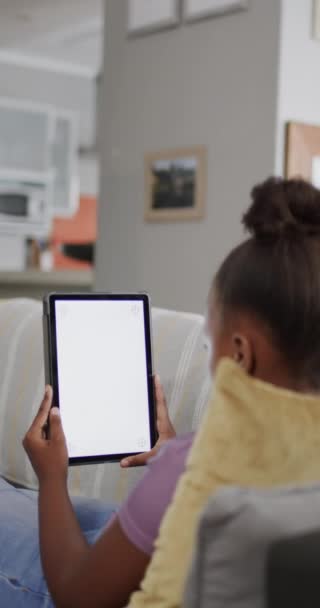Vídeo Vertical Una Chica Afroamericana Sentada Sofá Usando Una Tableta — Vídeos de Stock