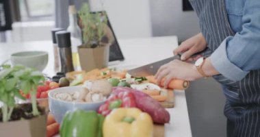 Melez bir kadının yemek hazırlama, mutfakta sebze doğrama, ağır çekim. Yemek, yemek, sağlıklı yaşam ve ev hayatı..