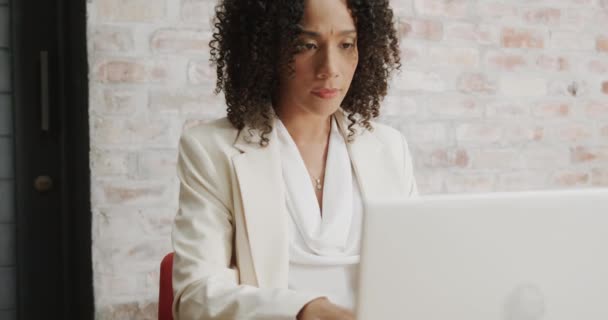 オフィスでラップトップを使用して机の上に座っている思慮深い産業界の女性は スローモーションで ビジネス コミュニケーション オフィス 変更なし — ストック動画