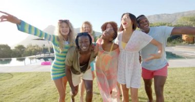 Güneşli havuz partisinde kucaklaşan ve eğlenen farklı arkadaşların portresi, yavaş çekim. Yaz, yaşam tarzı, arkadaşlık, kutlama ve parti, değişmeden.