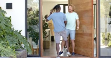 Evin ön kapısında kucaklaşan ve selamlaşan çeşitli erkek arkadaşların kutlu olsun, ağır çekimde. Yaz, dostluk, ev ve yaşam tarzı, değişmedi..