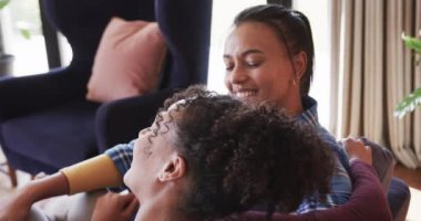 Romantik çift ırklı lezbiyen çift koltukta birlikte dinleniyor, gülüyorlar ve konuşuyorlar, ağır çekimde. Yaşam tarzı, ilişki, birliktelik, rahatlama, aşk ve ev hayatı, değişmemiş..